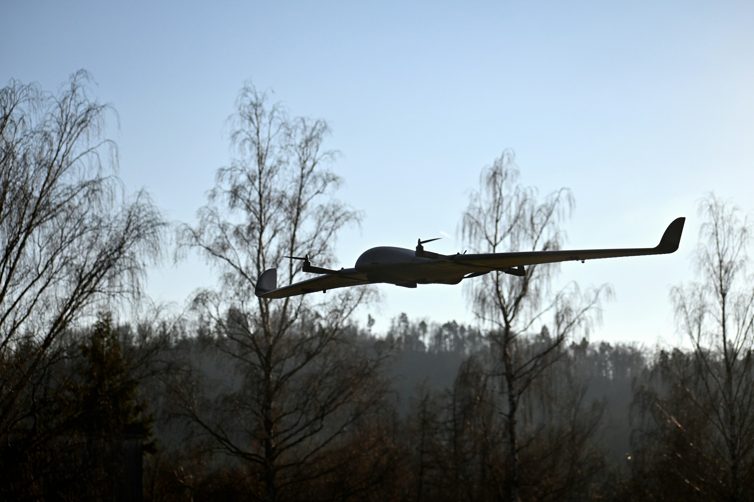 High-endurance fixed-wing UAS silhouette at dusk